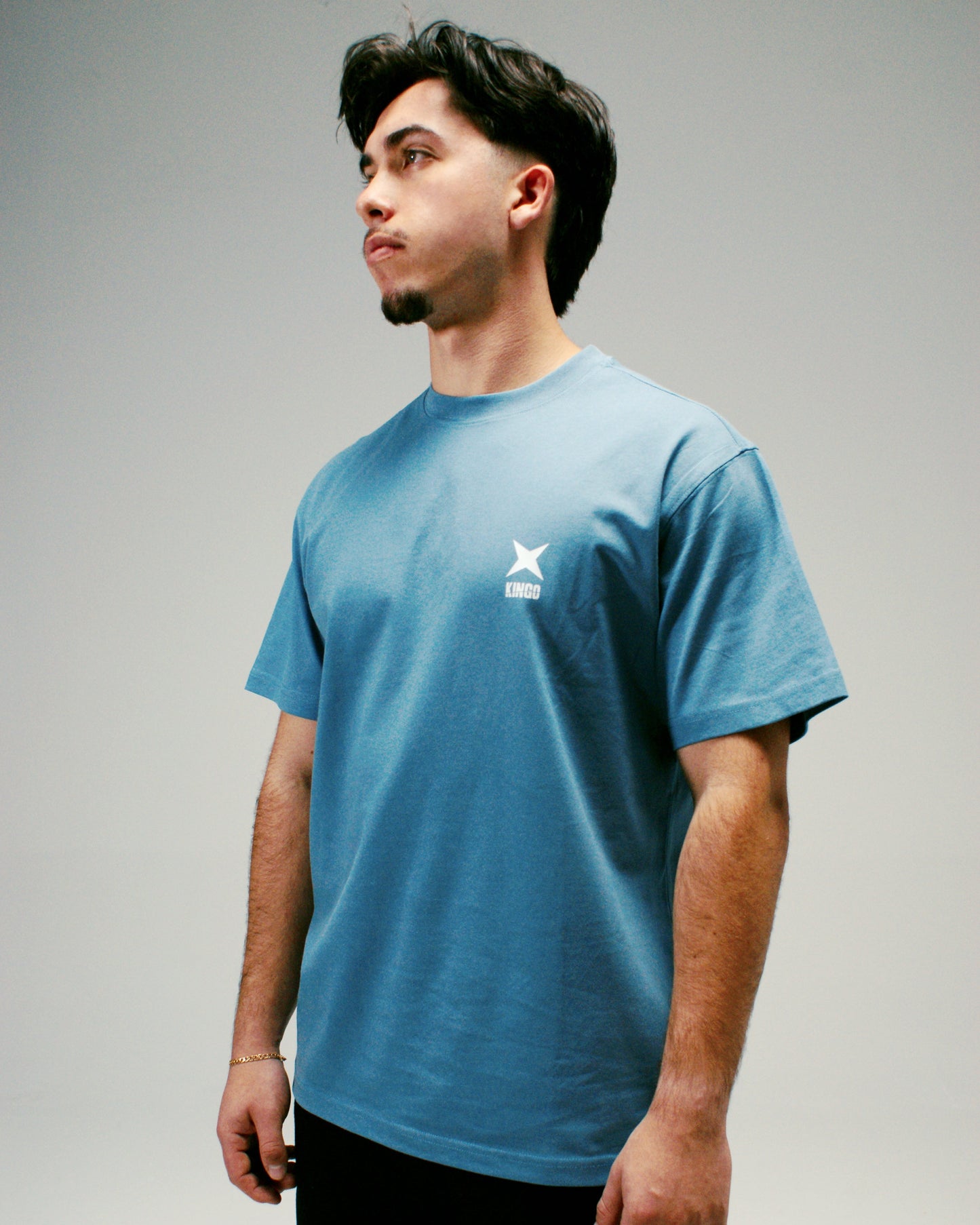 Homme portant un T-shirt Kingo oversize bleu, style décontracté et confortable.