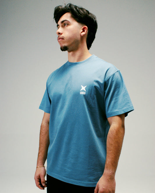 Homme portant un T-shirt Kingo oversize bleu, style décontracté et confortable.